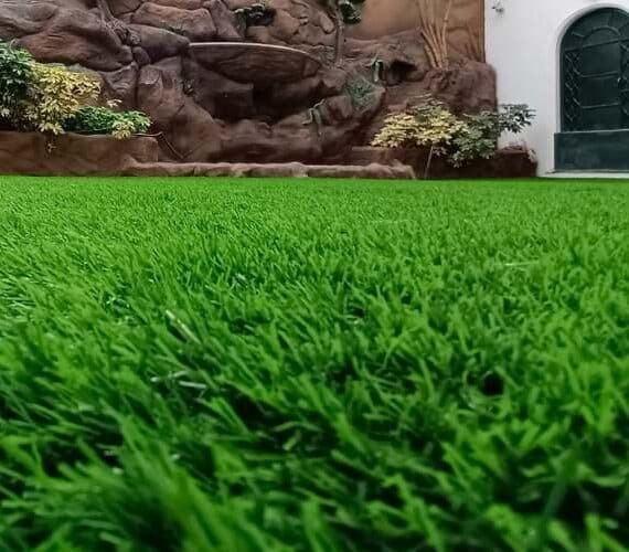 Low-angle view of 50mm (Florida) artificial grass installation in a premium garden landscape